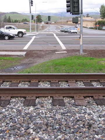 The "walk" signal lures people to walk across the tracks.