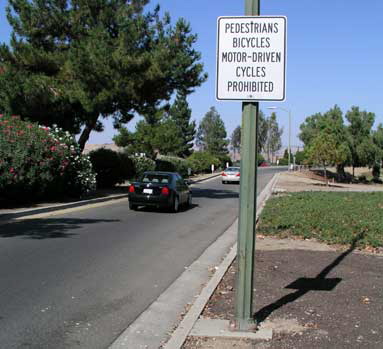 Posting "Pedestrians Bicycles ... Prohibited" is San Jose DOT's solution to the "pedestrian problem" but is illegal under CVC 21960 because Blossom Hill Road is not a freeway. (NE side)