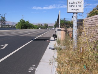 Distance, curb to wall, is 5 to 8 feet and is overgrown. Peds use shoulders here. Lengthen path and add ADA ramp from path to shoulder (former sidewal