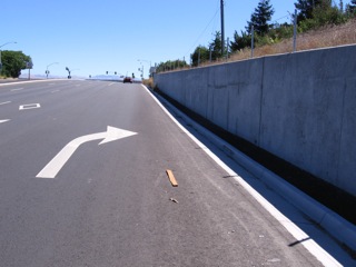 After bridge, new wall but no shoulder.